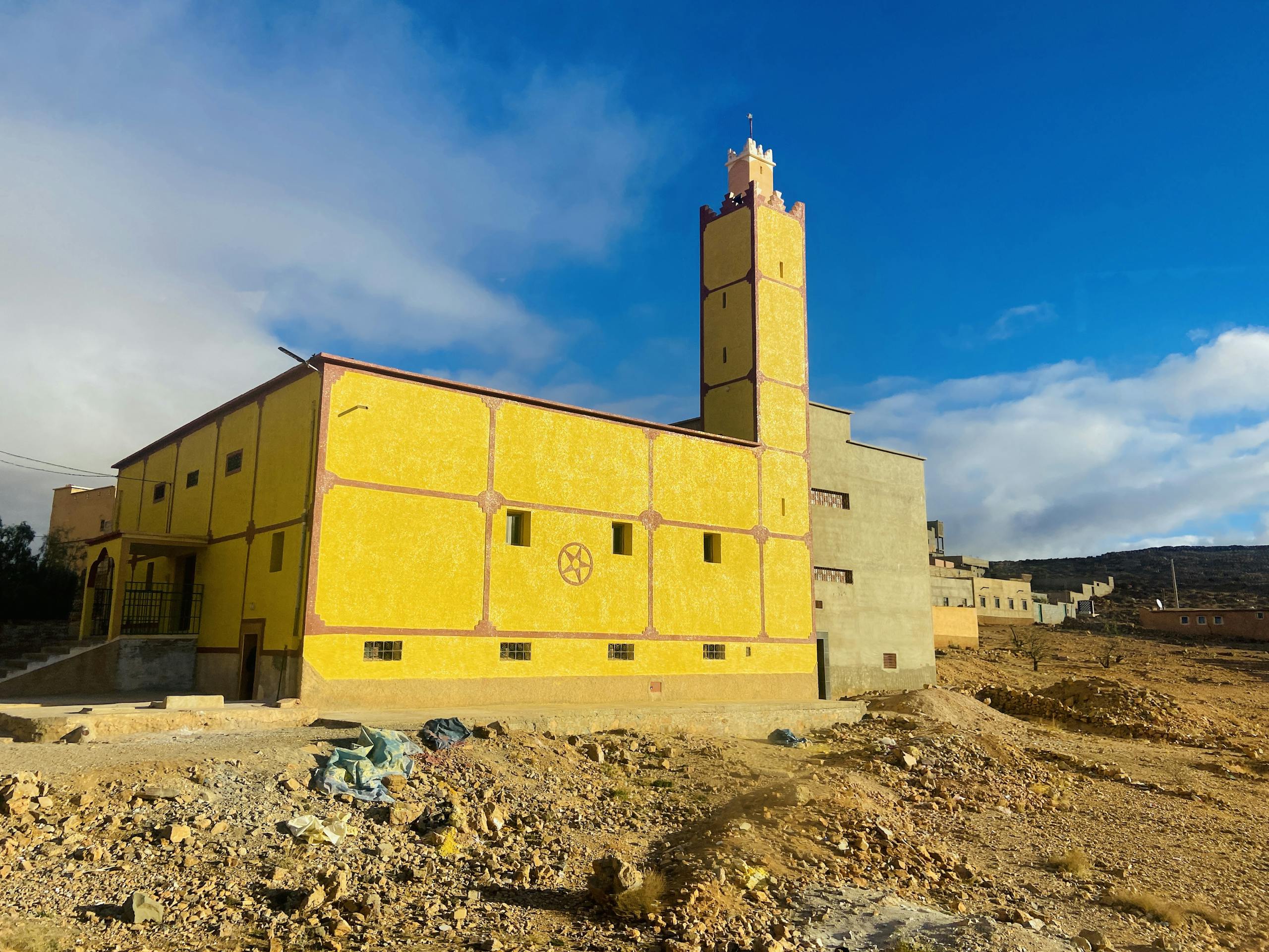 Beautiful yellow mosque in Taroudant, Morocco, showcasing unique architecture under a clear blue sky.